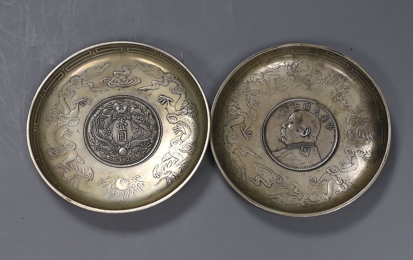 A pair of Chinese coin inserted dishes, 9cms diameter